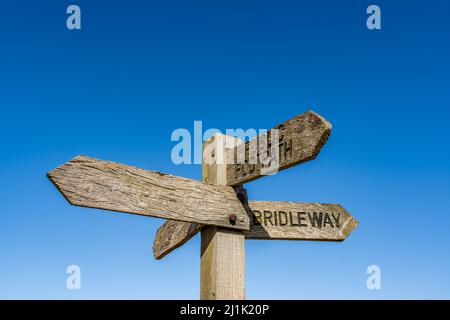 Multidirektionale Holzwegweiser mit öffentlichen Wegen und Stegen in der ländlichen Umgebung Stockfoto