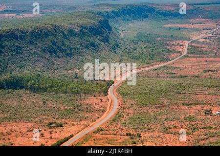 Luftaufnahme eines mit Sträuchern bedeckten Rückens des Great Rift Valley, parallel zu einer Hauptstraße, die nach Norden in Richtung Nairobi, Kenia, führt Stockfoto