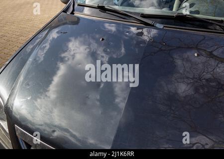 Motorhaube mit vielen Hagelschäden Dellen zeigen die Kräfte der Natur und die Bedeutung der Kfz-Versicherung und einer Ersatzwertversicherung gegen Stockfoto