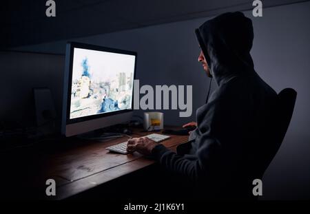 Hes ist ein Profi-Gamer. Aufnahme eines jungen Mannes, der nachts Computerspiele spielt. Stockfoto