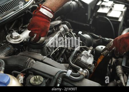 Mechaniker, der das Auto in der Kfz-Werkstatt inspiziert Stockfoto