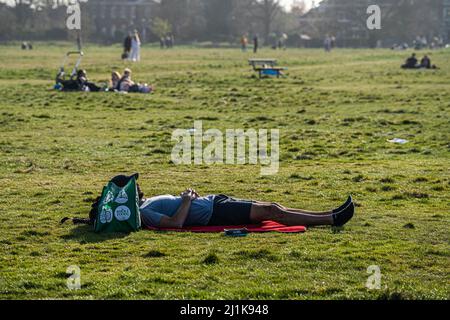 LONDON, GROSSBRITANNIEN. 26 März, 2022 . Ein Mann, der sich am Wimbledon Common an einem warmen Frühlingsnachmittag sonnt, da die Temperaturen voraussichtlich auf fast 68F/20C steigen werden. Großbritannien wird in die britische Sommerzeit umziehen, wobei die Uhren am 27. März eine Stunde nach vorne gehen.Quelle: amer ghazzal/Alamy Live News Stockfoto