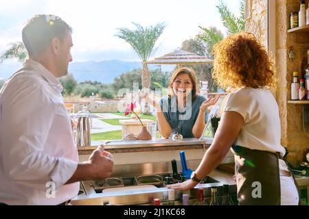 Mann und Frau, die in der Bar arbeiten und mit dem Kunden sprechen Stockfoto