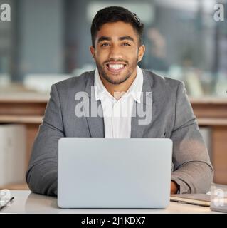 Glauben Sie mir, Sie haben keine Marke wie unsere gesehen. Aufnahme eines jungen Geschäftsmannes, der in einem modernen Büro einen Laptop benutzt. Stockfoto