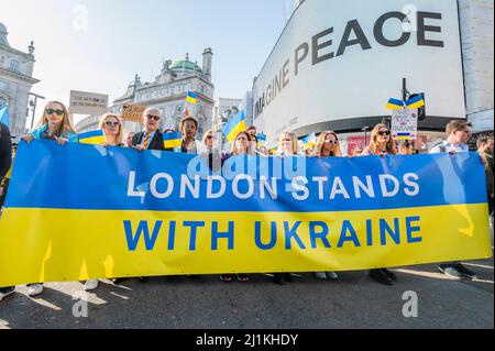 London, Großbritannien. 26. März 2022. ‘London steht bei der Ukraine' beginnt mit einem solidaritätsmarsch von der Park Lane aus, vorbei an Yoko Onos Botschaft ‘IMAGINE PEACE' auf den Piccadilly Lights und endet mit einer Mahnwache auf dem Trafalgar Square. Organisiert vom Bürgermeister von London, in Partnerschaft mit CIRCA und dem Yoko Ono ‘Imagine Peace'-Projekt, mit Unterstützung von Landsec. Jeder, der spenden möchte, um den Opfern von Konflikten zu helfen, wird dazu aufgefordert, dies über UNCERF (Central Emergency Response Fund der Vereinten Nationen) zu tun. Kredit: Guy Bell/Alamy Live Nachrichten Stockfoto