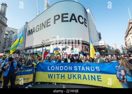 London, Großbritannien. 26. März 2022. Sadiq Khan, Bürgermeister von London, und David Lammy, Abgeordneter des Schattenaußenministers, nehmen an ‘‘London steht mit der Ukraine’ Teil, einem solidaritätsmarsch, der am Piccadilly Circus vorbei, wo Yoko Onos Botschaft „IMAGINE PEACE“ gezeigt wird, zu einer Mahnwache auf dem Trafalgar Square führt. Der ukrainische Präsident Wolodymyr Zelenski hat an Menschen in der ganzen Welt appelliert, auf die Straße zu gehen, um die Ukraine zu unterstützen, um einen Monat nach der russischen Invasion zu demonstrieren. Kredit: Stephen Chung / Alamy Live Nachrichten Stockfoto