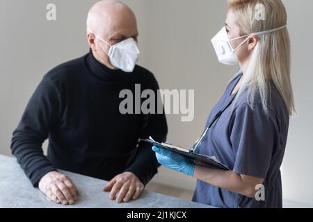 Arzt und älterer Mann mit Gesichtsmasken während des Coronavirus- und Grippeausbruchs. Schutz vor Viren und Krankheiten, Quarantäne zu Hause. COVID-2019. Stockfoto