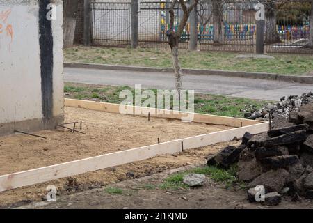 Vorbereitung des Blindbereichs des Fundaments. Grundlegende Schalungsmarkierung. Sackbereich Bau in der Nähe des Hauses. Stockfoto