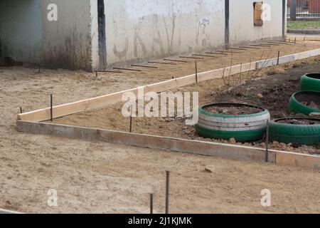 Vorbereitung des Blindbereichs des Fundaments. Grundlegende Schalungsmarkierung. Sackbereich Bau in der Nähe des Hauses. Stockfoto