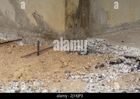 Vorbereitung des Blindbereichs des Fundaments. Grundlegende Schalungsmarkierung. Sackbereich Bau in der Nähe des Hauses. Hammer Eisenarmatur am Fuß des Hauses Stockfoto