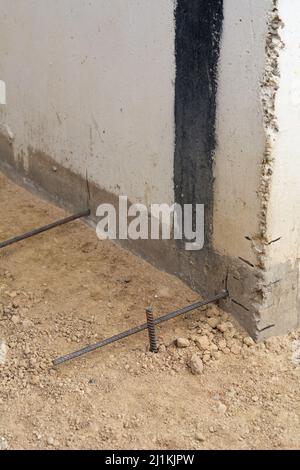 Vorbereitung des Blindbereichs des Fundaments. Grundlegende Schalungsmarkierung. Sackbereich Bau in der Nähe des Hauses. Hammer Eisenarmatur am Fuß des Hauses Stockfoto