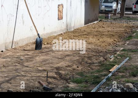 Vorbereitung des Blindbereichs des Fundaments. Grundlegende Schalungsmarkierung. Sackbereich Bau in der Nähe des Hauses. Stockfoto