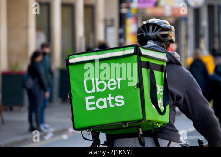 Cardiff, Wales - 2022. März: Fahrradkurier für die Uber isst Food Delivery Service, der durch das Stadtzentrum fährt Stockfoto