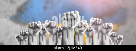 Unterstützung der Ukraine und Solidarität. Hilfe für das ukrainische Volk in Kriegszeiten. Fäuste als Symbol der Unterstützung vor dem Hintergrund der ukrainischen Flagge Stockfoto