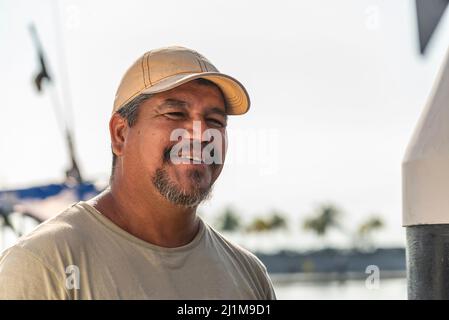 Porträt eines reifen lateinischen Fischers, der am Kai lächelt Stockfoto