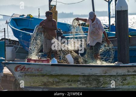 Arme lateinische Fischer, die die Netze für die Fischerei vorbereiten Stockfoto