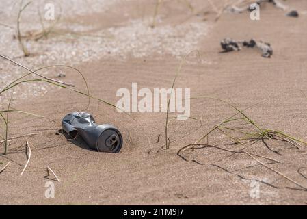 Lange verlassene AluminiumDose auf dem Sand in Strandnähe. Konzept kümmern sich um die Erde. Stockfoto