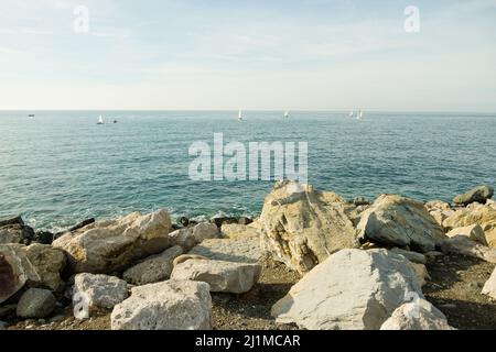 Meereswellen am Rocky Beach, wunderschöne Nahaufnahmen von Meereswellen, die Strandkiesel waschen. Wunderschöne Küste, horizontal. Die Wellen erreichen Stockfoto