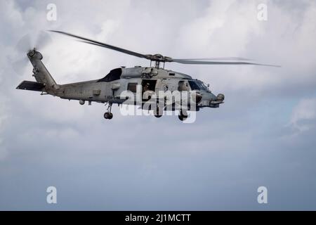 PHILIPPINISCHES MEER (24. März 2022) LT. Cmdr. Michael Hatch, Air Boss von Helicopter Maritime Strike Squadron (HSM) 51, aus Mobile, Alabama, LT. Olivia Czerewko, aus Lemoore, Kalifornien und Naval Air Crewman (Hubschrauber) 2. Class Baldwin Schweitzer aus Ocala, Florida, bieten an Bord des Arleigh Burke-Klasse Lenkflugkörper-Zerstörers USS Dewey (DDG 105) eine Reichweite für Live-Feuerübungen, während sie im Verantwortungsbereich der US 7.-Flotte unterwegs sind. Dewey wird Destroyer Squadron (DESRON) 15 zugewiesen und unterstützt derzeit einen freien und offenen Indo-Pacific. CTF 71/DESRON 15 ist die größte Marine Stockfoto