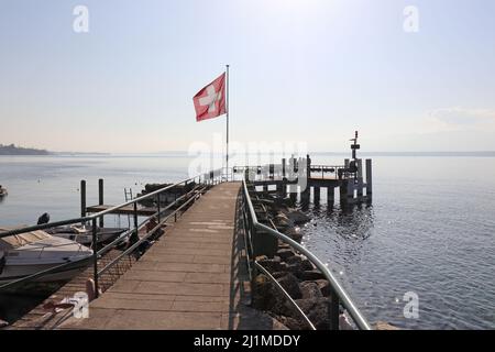 Deck mit Schweizer Flagge vor dem Lake Leman an einem schönen sonnigen Tag Stockfoto