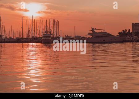 Sonnenaufgang an der Küste. In der Silhouette der Schiffe im Hafen. Selektiver Fokus Stockfoto