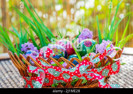 Gestreiftes Band zur Dekoration eines Holzkorbes voller Ostereier Stockfoto