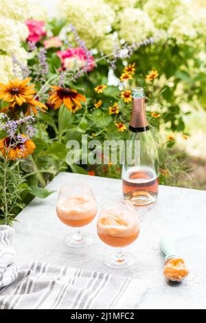 Champaign Floats serviert im Freien auf einer Sommerterrasse mit Sherbet und Rose Bubbles Stockfoto