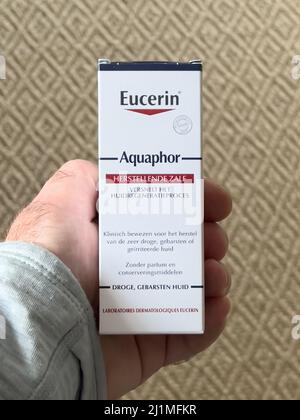 Paris, Frankreich - 3. Jan 2022: POV männliche Hand-Paket mit Eucerin Aquaphor herstellende ZALF Skin Repair Balm Stockfoto