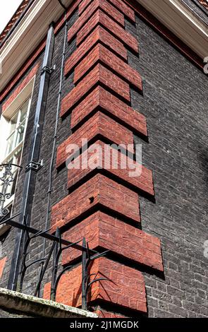 Niedriger Winkel Ansicht einer Ecke mit roten Ziegelsteinquoins, London, England, Großbritannien. Stockfoto