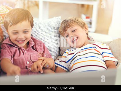 Ich möchte alle meine Spiele sehen. Aufnahme von zwei kleinen Jungen, die zusammen einen Laptop benutzen. Stockfoto