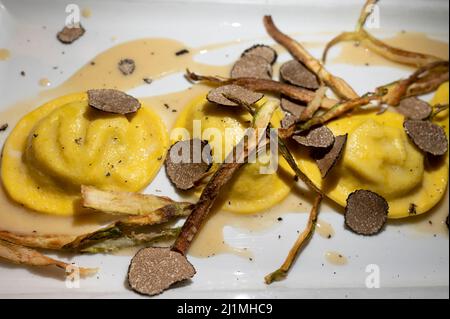 Italienische Küche, frisch hausgemachte rote Kartoffel gefüllte Pasta Tortellacci oder Ravioli Knödel mit sommerlichen schwarzen Trüffeln und knusprigen grünen Spargel, Parma, E Stockfoto