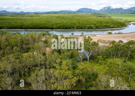 Draußen auf dem Land in der Nähe eines von Buschland umgebenen Baches. Entfernte Bergkette. Salzpflatten auf trockenem Mineralbett. Drohnenlandschaft. Stockfoto