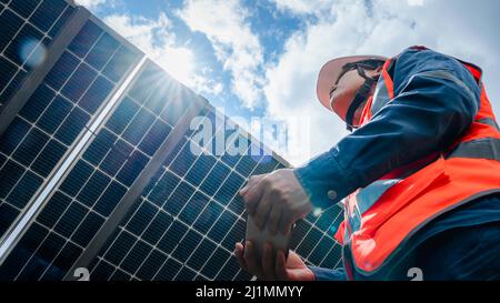 Low-Winkel-Ansicht des Solarparks (Solarpanel) mit Ingenieuren überprüfen Sie den Betrieb des Systems, Alternative Energie, um die Energie der Welt zu sparen, Photovo Stockfoto