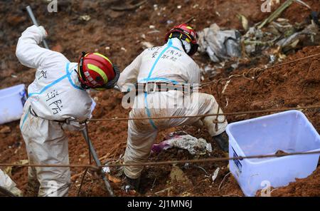 (220327) -- TENGXIAN, 27. März 2022 (Xinhua) -- Rettungskräfte, die mit Sicherheitsschnüren gesichert sind, führen Such- und Rettungsarbeiten an der Flugzeugabsturzstelle im Bezirk Tengxian, südchinesische Autonome Region Guangxi Zhuang, 26. März 2022. Alle 132 Personen an Bord des Flugzeugs von China Eastern Airlines, das am Montag in der Autonomen Region Guangxi Zhuang im Süden Chinas abgestürzt ist, waren tot, teilte ein offizieller Vertreter am Samstag mit. l-o Credit: Xinhua/Alamy Live News Stockfoto