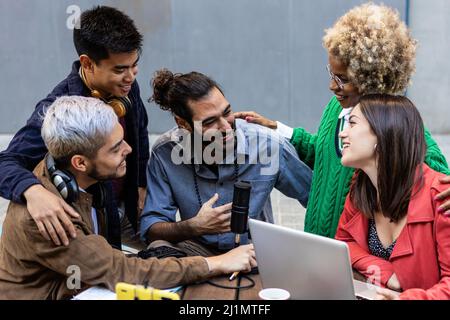 Multirassische, vielfältige Studentenfreunde, die gemeinsam Hausaufgaben machen, während sie einen Laptop verwenden Stockfoto