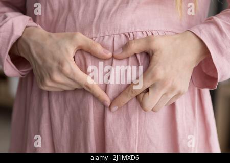 Close up glücklich junge Schwangere Frau macht Liebe Zeichen. Stockfoto