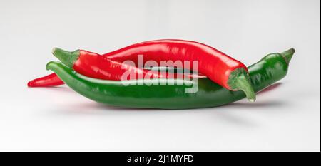 Drei reife Chilischoten isoliert auf weißem Hintergrund. Rote und grüne scharfe Chilischote. Reife rote und grüne Chili-Paprika Gemüse. Roter Cayennepfeffer Stockfoto