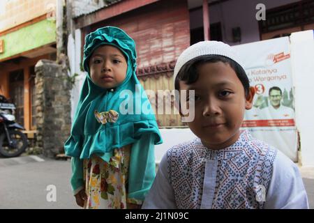 Jakarta, Indonesien - 01 03 2021: Mädchen in Hijabs und Jungen, die während der Eid al-Fitr 1441 Hijri auf den Straßen von Jakarta auf die Kamera starrten Stockfoto