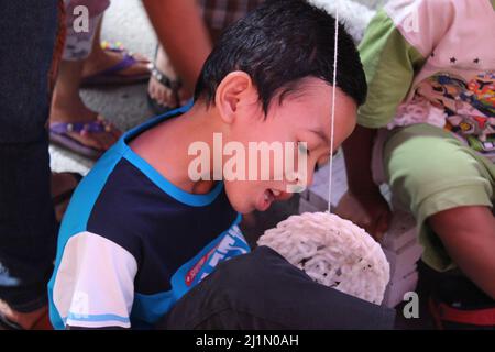 Jakarta, Indonesien - 01 03 2021: Junge, der während der indonesischen Unabhängigkeitsveranstaltung 72. auf einer Straße im Raum Jakarta um Cracker konkurriert Stockfoto