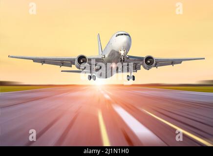 Großes Flugzeug in Bewegung Start der Abendhimmel Sonnenuntergang Sonnenaufgang Sonne Flughafen. Stockfoto