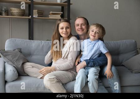 Junge, schwanger Mutter und lächelnder Vater kuscheln mit dem kleinen Sohn. Stockfoto