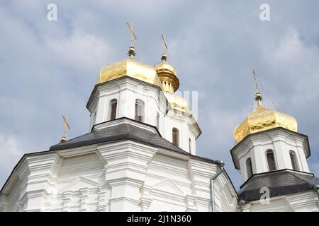 Vergoldete Kuppeln einer alten orthodoxen Kirche gegen den Himmel. Die Katharinenkirche ist eine funktionierende Kirche in Tschernihiw Stockfoto