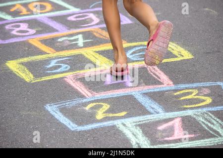 Kleines Mädchen spielt hopscotch. Selektiver Fokus Stockfoto