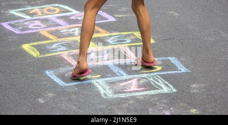 Kleines Mädchen spielt hopscotch. Selektiver Fokus Stockfoto