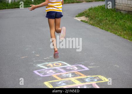 Kleines Mädchen spielt hopscotch. Selektiver Fokus Stockfoto