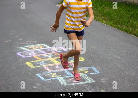 Kleines Mädchen spielt hopscotch. Selektiver Fokus Stockfoto