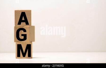 Hauptversammlung Abkürzung für Holzwürfel auf blauem Hintergrund. Geschäftskonzept. Stockfoto