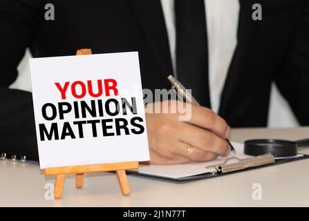 Closeup auf Geschäftsmann hielt eine Karte mit Text YOUR OPINION MATTERS, Firmen-Konzept-Image mit soft-Fokus-Hintergrund und Vintage-Ton Stockfoto