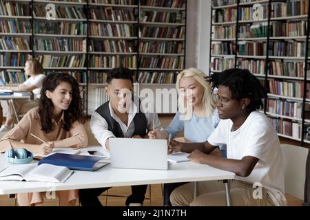 Studenten am Schreibtisch in der Bibliothek bereiten sich auf die Prüfungen mit einem Laptop vor Stockfoto