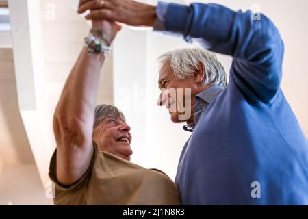 Ältere Paare tanzen, sie schauen zusammen in ihre Augen, alte verheiratete Menschen in der Liebe Stockfoto